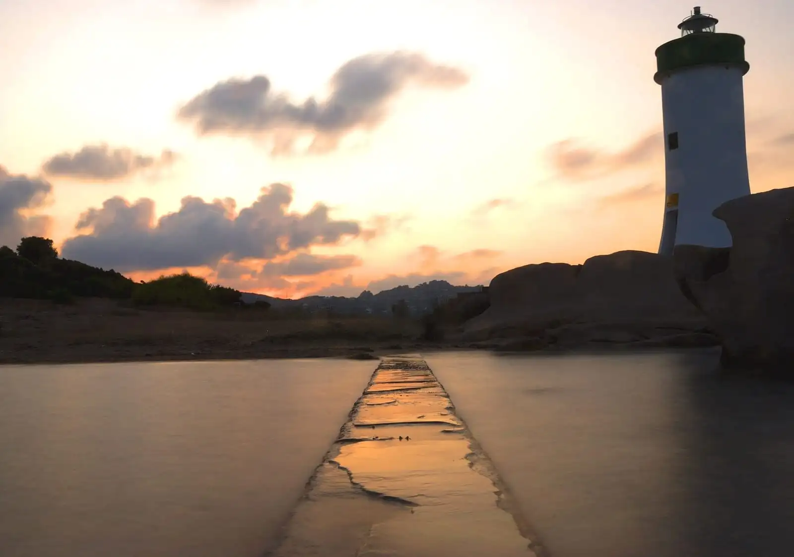 Tramonto sul faro e sul molo di Palau con l'arcipelago sullo sfondo