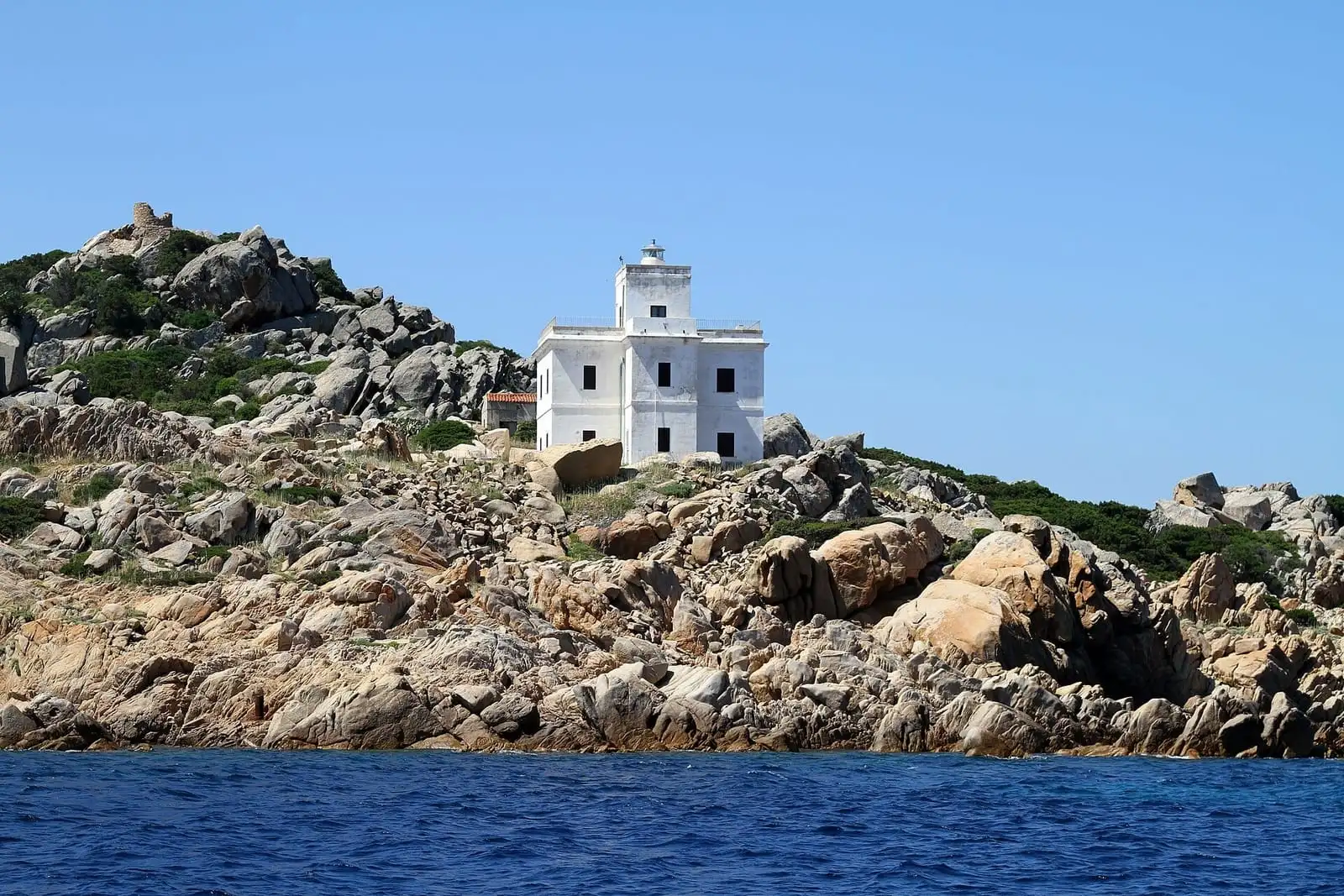 Il faro bianco di Punta Sardegna a Palau visto dal mare, all'uscita del porto